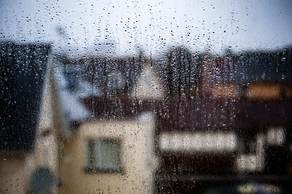 Rain streaking down a window over Kent rooftops