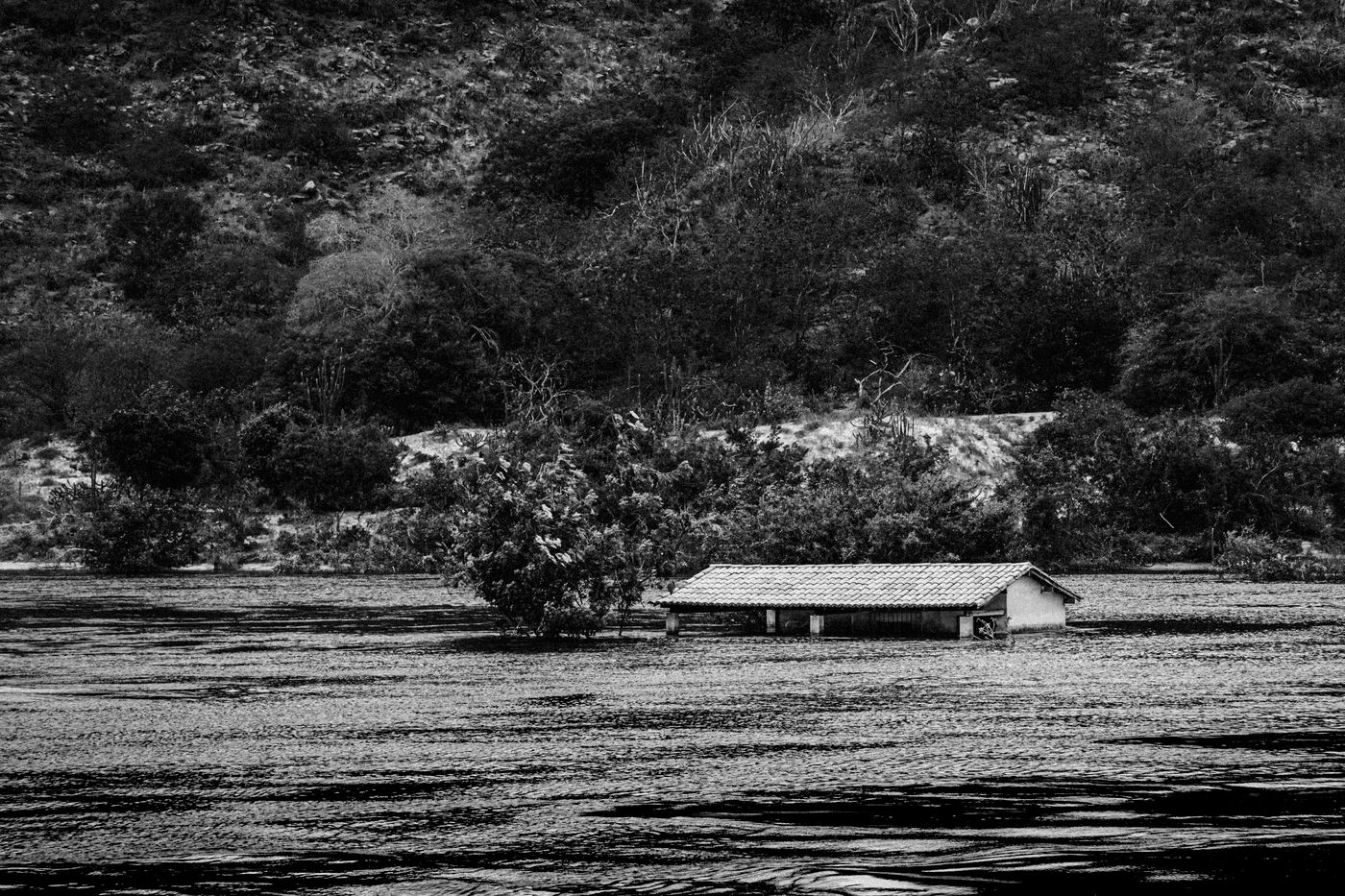 A home surrounded by dark flood water